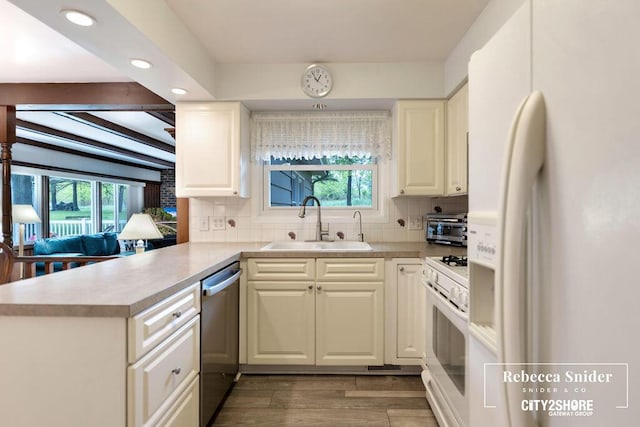 9409 Whitneyville Ave SE, Alto, MI 49302 - kitchen featuring white appliances, a sink, wood finished floors, tasteful backsplash, and a peninsula