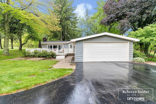 9409 Whitneyville Ave SE, Alto, MI 49302 - view of front facade with a chimney, a front lawn, a deck, and a garage