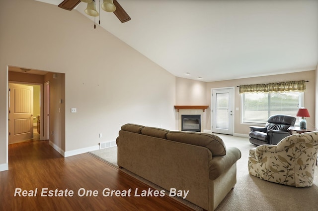 32 Tuscany Cir, Saginaw, MI 48603 - living room featuring baseboards, a tiled fireplace, a ceiling fan, wood finished floors, and high vaulted ceiling