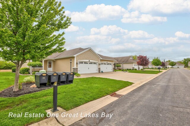32 Tuscany Cir, Saginaw, MI 48603 - view of front of property featuring an attached garage, a front yard, concrete driveway, and stone siding
