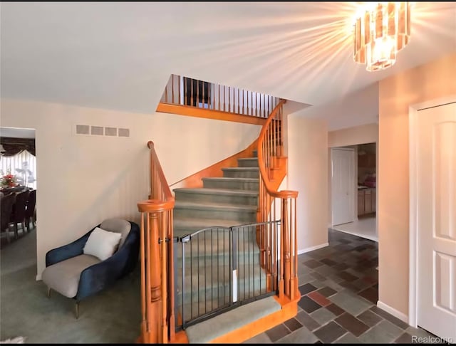 31929 Cambridge Dr, Clinton Township, MI 48093 - stairs with baseboards, stone finish flooring, and a chandelier