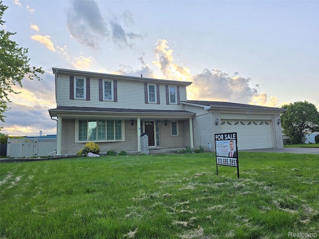 31929 Cambridge Dr, Clinton Township, MI 48093 - traditional-style house featuring an attached garage, asphalt driveway, a front lawn, and covered porch