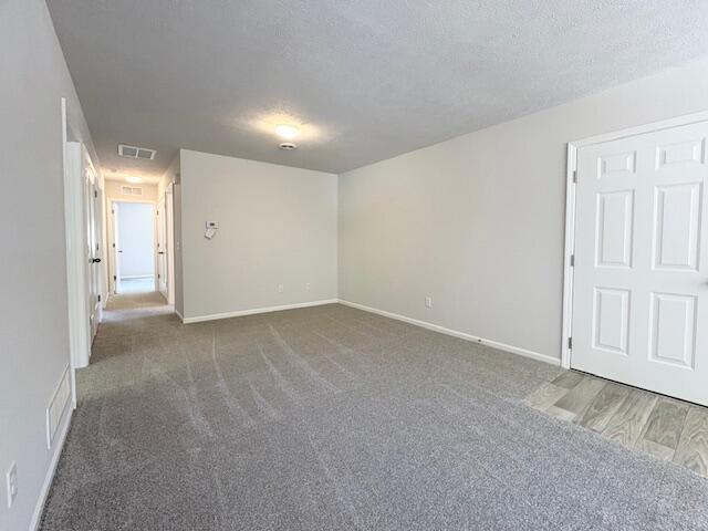 8121 Bowens Mill Rd, Middleville, MI 49333 - empty room with baseboards, carpet flooring, and a textured ceiling