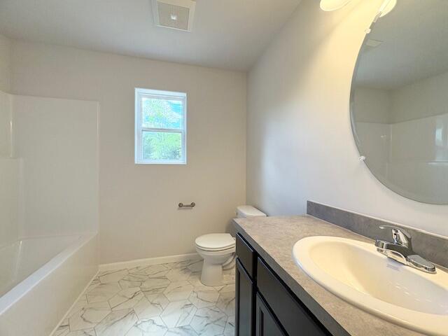 8121 Bowens Mill Rd, Middleville, MI 49333 - bathroom featuring vanity, toilet, marble finish floors, baseboards, and shower / bathtub combination
