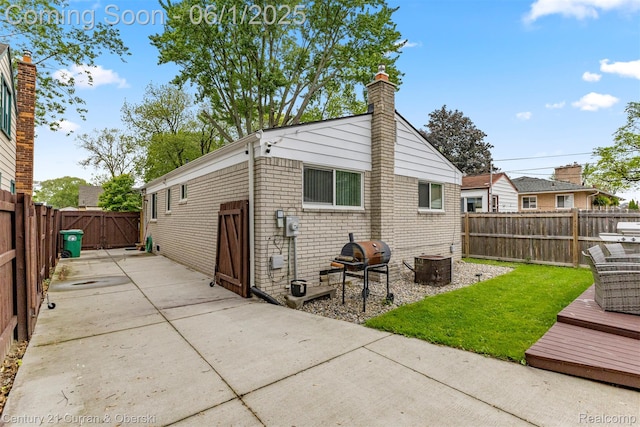 5908 Gilman St, Garden City, MI 48135 - rear view of property with a patio, a chimney, and brick siding