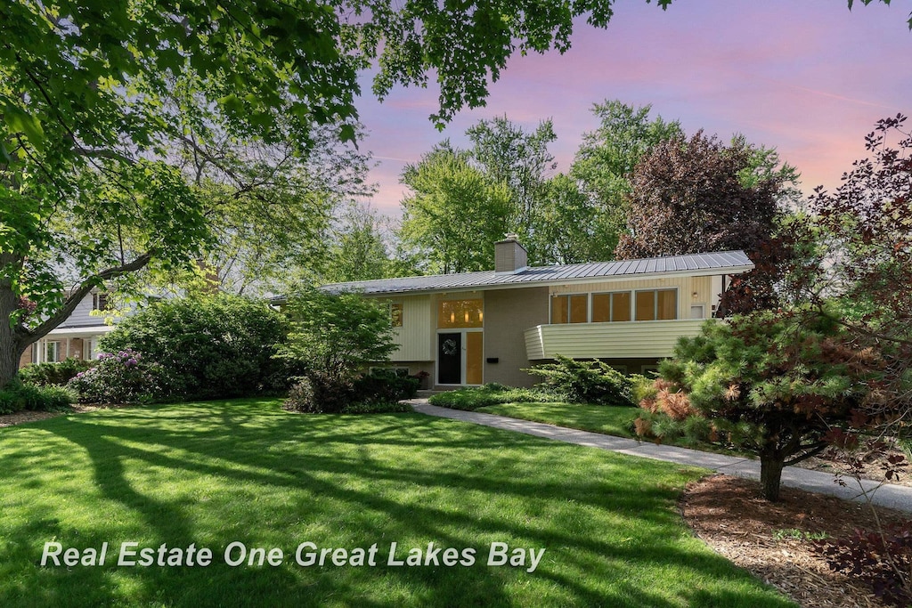 519 Linwood Dr, Midland, MI 48640 - raised ranch featuring a chimney, a lawn, and metal roof