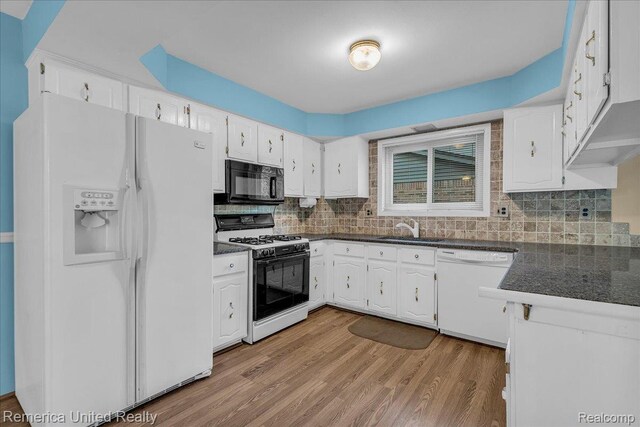 3455 Harmony Dr, Troy, MI 48083 - kitchen featuring white appliances, dark countertops, light wood-type flooring, white cabinets, and tasteful backsplash