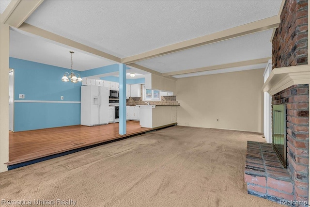 3455 Harmony Dr, Troy, MI 48083 - unfurnished living room with beamed ceiling, a chandelier, a brick fireplace, light carpet, and a textured ceiling