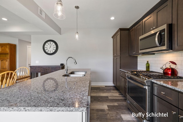 334 Terrace Point Cir Unit 33, Muskegon, MI 49440 - kitchen featuring a sink, stainless steel appliances, backsplash, light stone countertops, and dark brown cabinetry