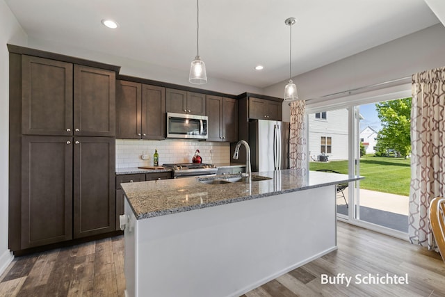 334 Terrace Point Cir Unit 33, Muskegon, MI 49440 - kitchen featuring stainless steel appliances, a sink, dark brown cabinetry, wood finished floors, and tasteful backsplash