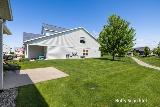 334 Terrace Point Cir Unit 33, Muskegon, MI 49440 - back of property featuring a yard, a patio area, and roof with shingles