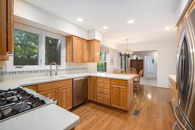 3509 Sulgrave Pl, Ann Arbor, MI 48105 - kitchen with appliances with stainless steel finishes, a sink, a peninsula, light countertops, and recessed lighting