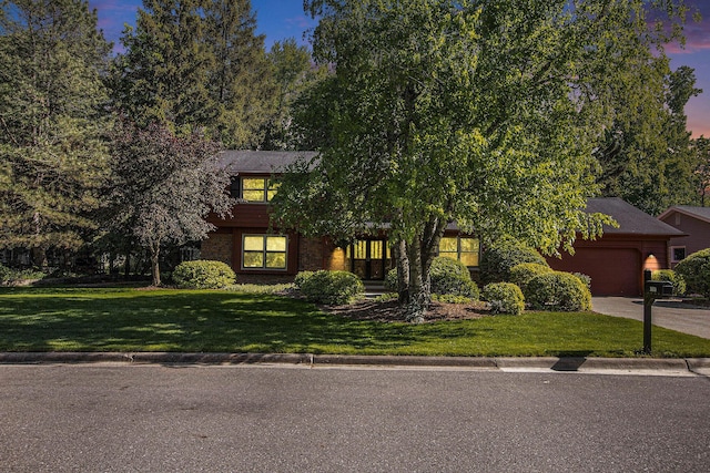 3509 Sulgrave Pl, Ann Arbor, MI 48105 - view of property hidden behind natural elements with an attached garage, driveway, a front lawn, and brick siding