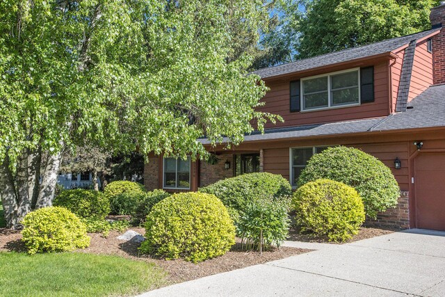 3509 Sulgrave Pl, Ann Arbor, MI 48105 - view of front of house featuring a shingled roof, a chimney, and a garage