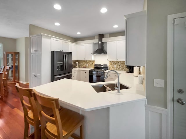 4315 Astoria Ave SE, Grand Rapids, MI 49512 - kitchen with black appliances, wall chimney range hood, a sink, a peninsula, and decorative backsplash