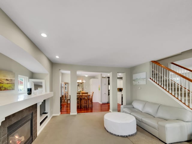4315 Astoria Ave SE, Grand Rapids, MI 49512 - carpeted living area featuring a chandelier, stairway, a tile fireplace, recessed lighting, and baseboards