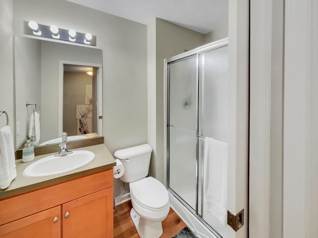 4315 Astoria Ave SE, Grand Rapids, MI 49512 - bathroom featuring a stall shower, toilet, vanity, and wood finished floors