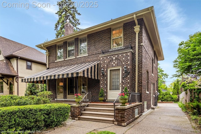 1377 Bishop Rd, Grosse Pointe Park, MI 48230 - view of front of property featuring brick siding, a chimney, a standing seam roof, metal roof, and covered porch