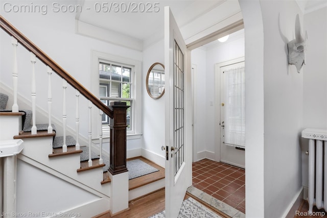 1377 Bishop Rd, Grosse Pointe Park, MI 48230 - foyer featuring radiator heating unit, stairs, baseboards, and arched walkways