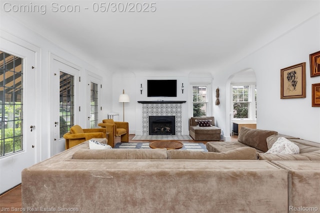 1377 Bishop Rd, Grosse Pointe Park, MI 48230 - living area with a tiled fireplace, wood finished floors, and arched walkways