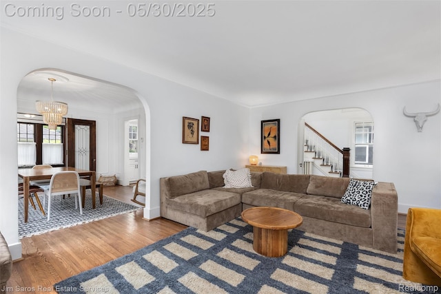 1377 Bishop Rd, Grosse Pointe Park, MI 48230 - living room with arched walkways, a chandelier, stairs, wood finished floors, and baseboards