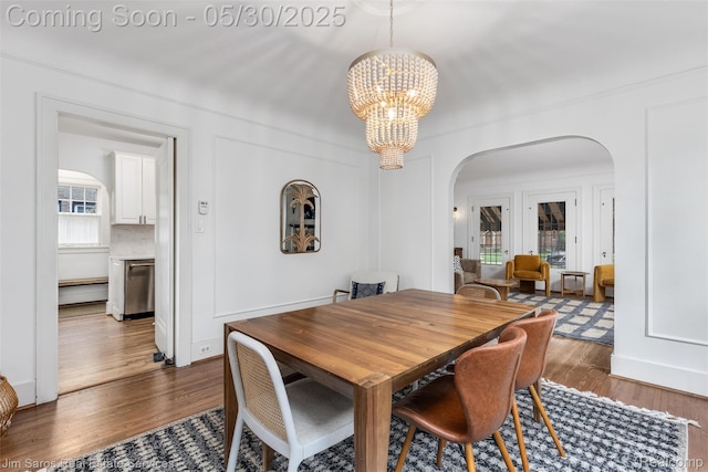 1377 Bishop Rd, Grosse Pointe Park, MI 48230 - dining area featuring arched walkways, a chandelier, and wood finished floors