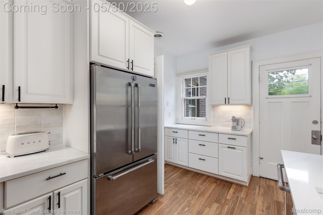 1377 Bishop Rd, Grosse Pointe Park, MI 48230 - kitchen featuring high quality fridge, tasteful backsplash, light wood finished floors, white cabinets, and light countertops