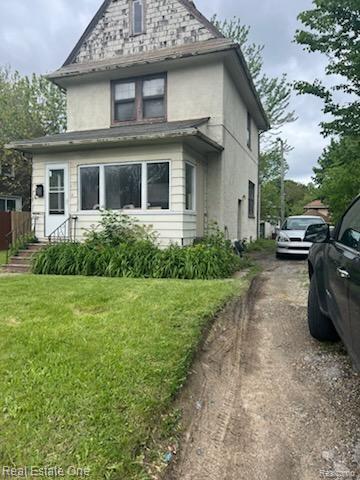 633 N Perry St, Clarkston, MI 48342 - view of front facade with a front lawn and stucco siding