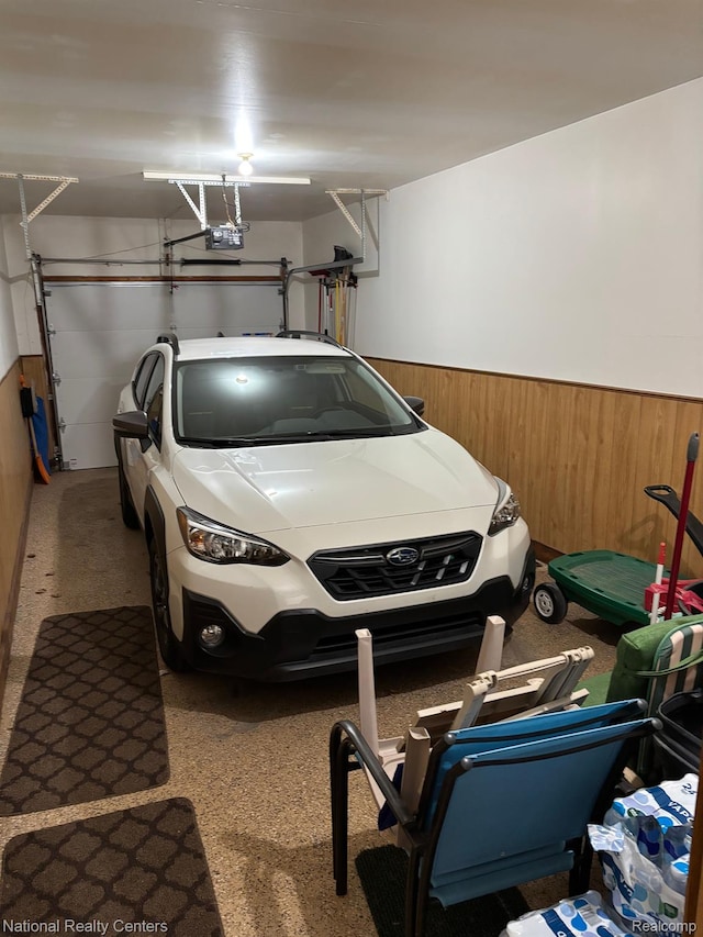 14764 Brewster Ct, Shelby Twp, MI 48315 - garage featuring wainscoting, a garage door opener, and wood walls