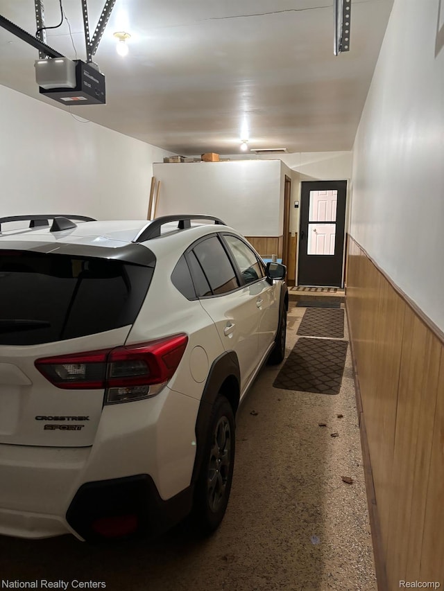 14764 Brewster Ct, Shelby Twp, MI 48315 - garage with wood walls, a wainscoted wall, and a garage door opener