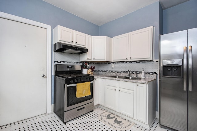 928 Baxter St SE, Grand Rapids, MI 49506 - kitchen with appliances with stainless steel finishes, under cabinet range hood, a sink, decorative backsplash, and white cabinetry