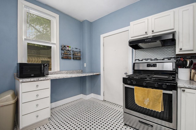 928 Baxter St SE, Grand Rapids, MI 49506 - kitchen with stainless steel gas range, under cabinet range hood, black microwave, white cabinetry, and backsplash