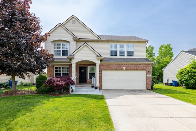 1743 Savannah Ln, Ypsilanti, MI 48198 - traditional-style house with an attached garage, brick siding, a front yard, concrete driveway, and roof with shingles