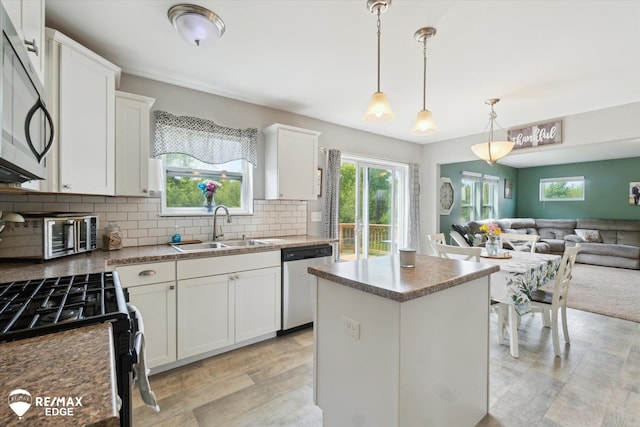 9416 Sunrise Ln, Davison, MI 48423 - kitchen with appliances with stainless steel finishes, a sink, a kitchen island, open floor plan, and white cabinetry