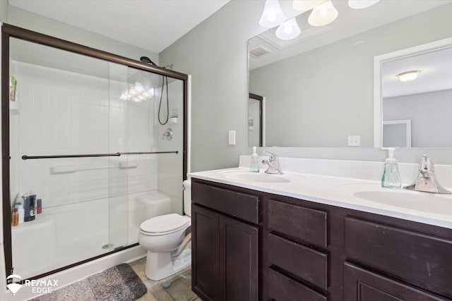9416 Sunrise Ln, Davison, MI 48423 - bathroom featuring toilet, a stall shower, double vanity, and wood finished floors