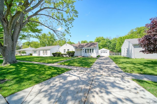 962 Vine St, Adrian, MI 49221 - view of front of property featuring driveway, a garage, a front yard, an outbuilding, and a chimney