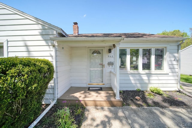 962 Vine St, Adrian, MI 49221 - view of exterior entry with a chimney and a shingled roof