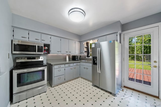 962 Vine St, Adrian, MI 49221 - kitchen with stainless steel appliances, light floors, and gray cabinets