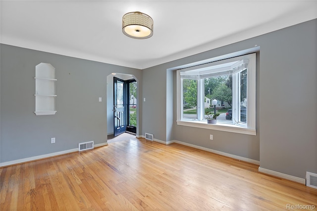717 N Vermont Ave, Royal Oak, MI 48067 - unfurnished room with arched walkways, light wood finished floors, and baseboards