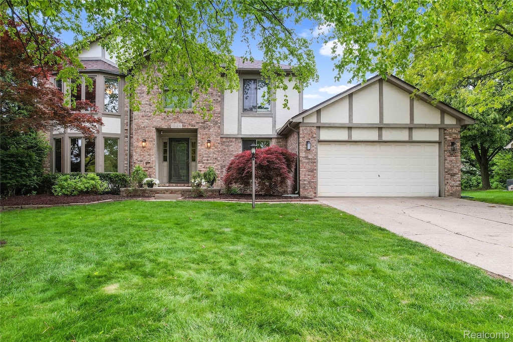 1036 Bembridge Dr, Rochester Hills, MI 48307 - tudor-style house featuring a garage, driveway, a front yard, and brick siding