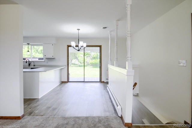 2680 N Lake George Rd, Metamora, MI 48455 - kitchen featuring a baseboard heating unit, white cabinets, a chandelier, light countertops, and wood finished floors