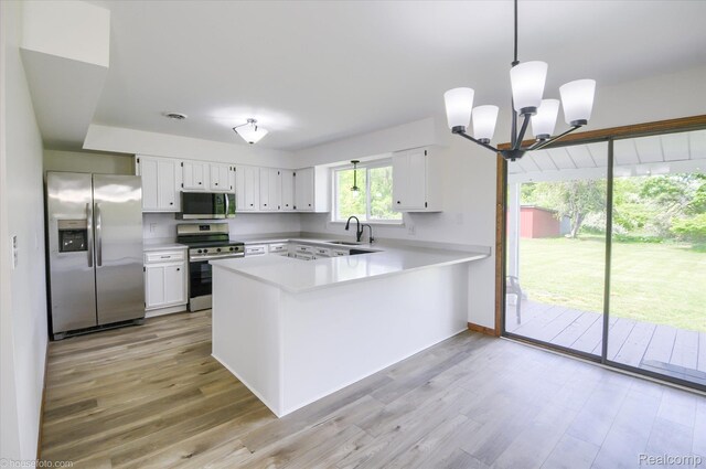 2680 N Lake George Rd, Metamora, MI 48455 - kitchen with appliances with stainless steel finishes, a sink, a peninsula, light countertops, and a chandelier