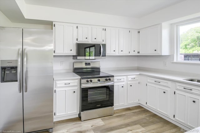 2680 N Lake George Rd, Metamora, MI 48455 - kitchen featuring stainless steel appliances, white cabinetry, light countertops, and light wood-style flooring