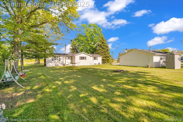3889 Wadhams Rd, Clyde, MI 48049 - view of grassy yard featuring an outdoor fire pit