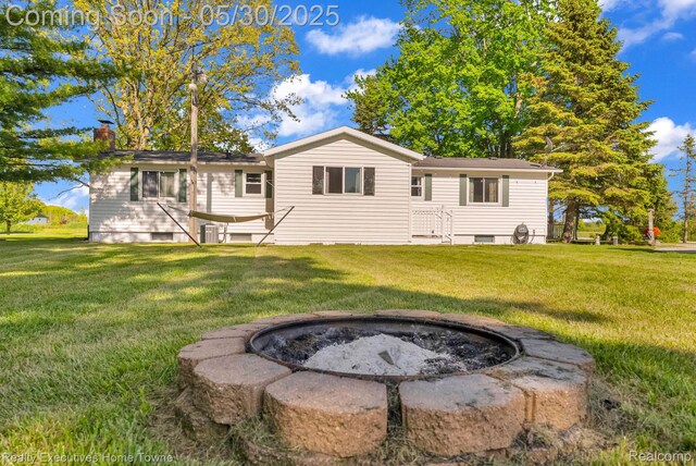 3889 Wadhams Rd, Clyde, MI 48049 - back of house with an outdoor fire pit, a chimney, and a lawn