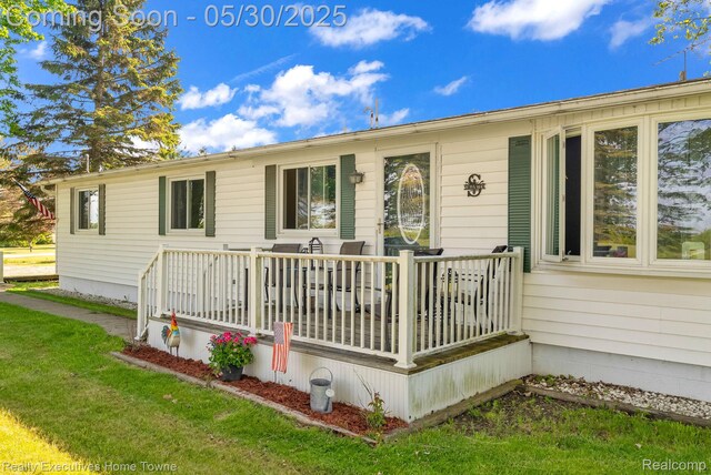 3889 Wadhams Rd, Clyde, MI 48049 - view of front of property with a wooden deck and a front yard