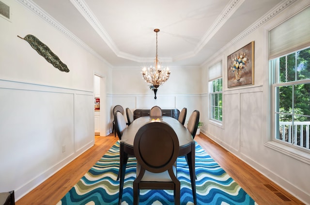 1796 Stockbridge Path, Saint Joseph, MI 49085 - dining area with wood finished floors, a chandelier, a decorative wall, a raised ceiling, and crown molding