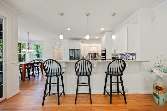 1796 Stockbridge Path, Saint Joseph, MI 49085 - kitchen featuring stainless steel fridge, a peninsula, tasteful backsplash, white oven, and crown molding