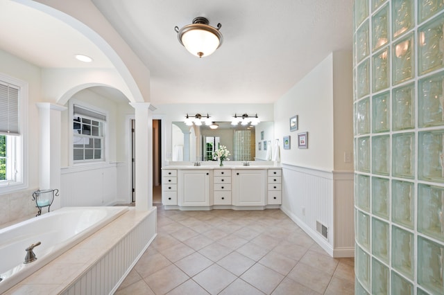1796 Stockbridge Path, Saint Joseph, MI 49085 - bathroom with double vanity, ornate columns, tile patterned floors, a bath, and wainscoting