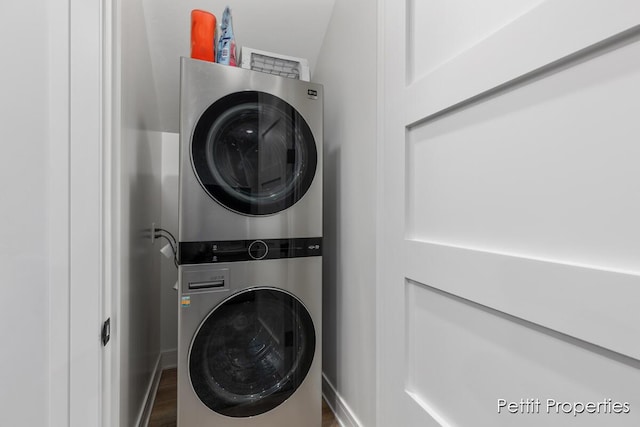 1509 Ponstein Dr, Hudsonville, MI 49426 - laundry area featuring stacked washer and clothes dryer, wood finished floors, and baseboards